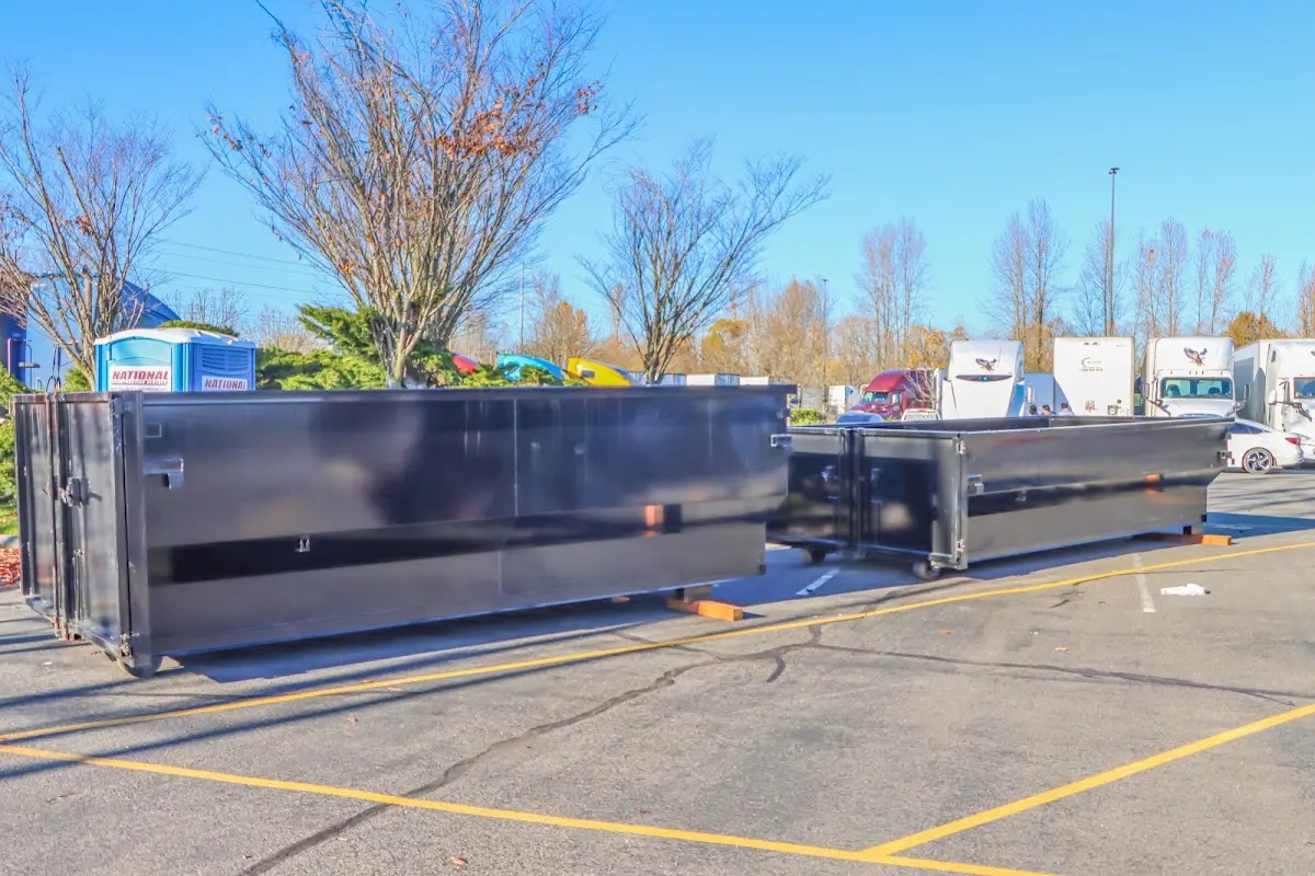 Professional dumpster rental service with roll-off container on residential driveway in Green